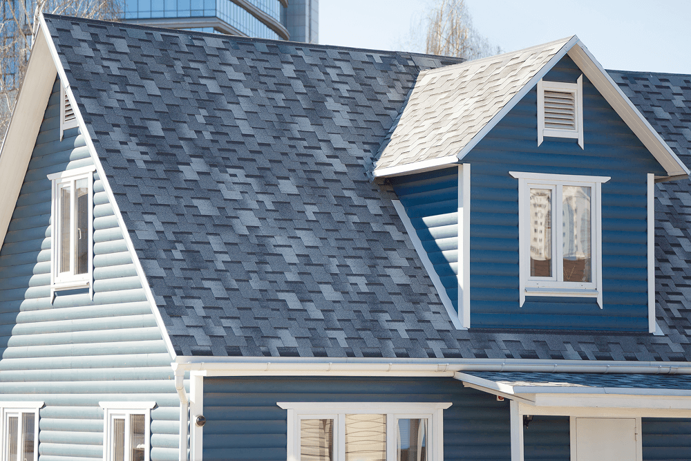 Roof with gray shingles and blue siding on a house, showcasing durable exterior materials suitable for Mississippi's climate, emphasizing Tekton Exteriors' siding installation services.