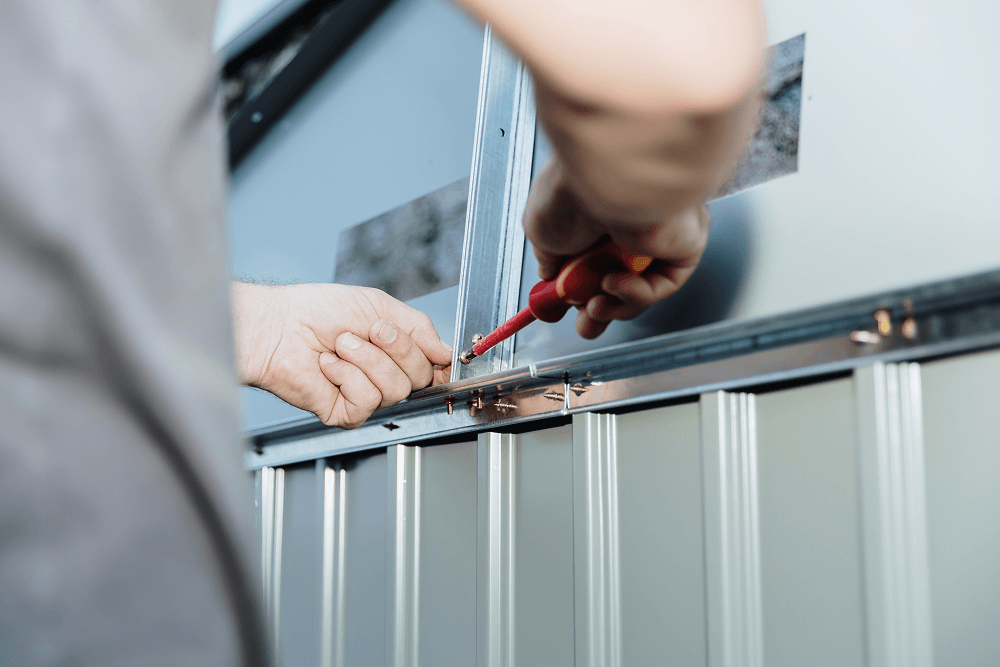 Person installing siding with a screwdriver, showcasing precision craftsmanship for exterior home solutions.