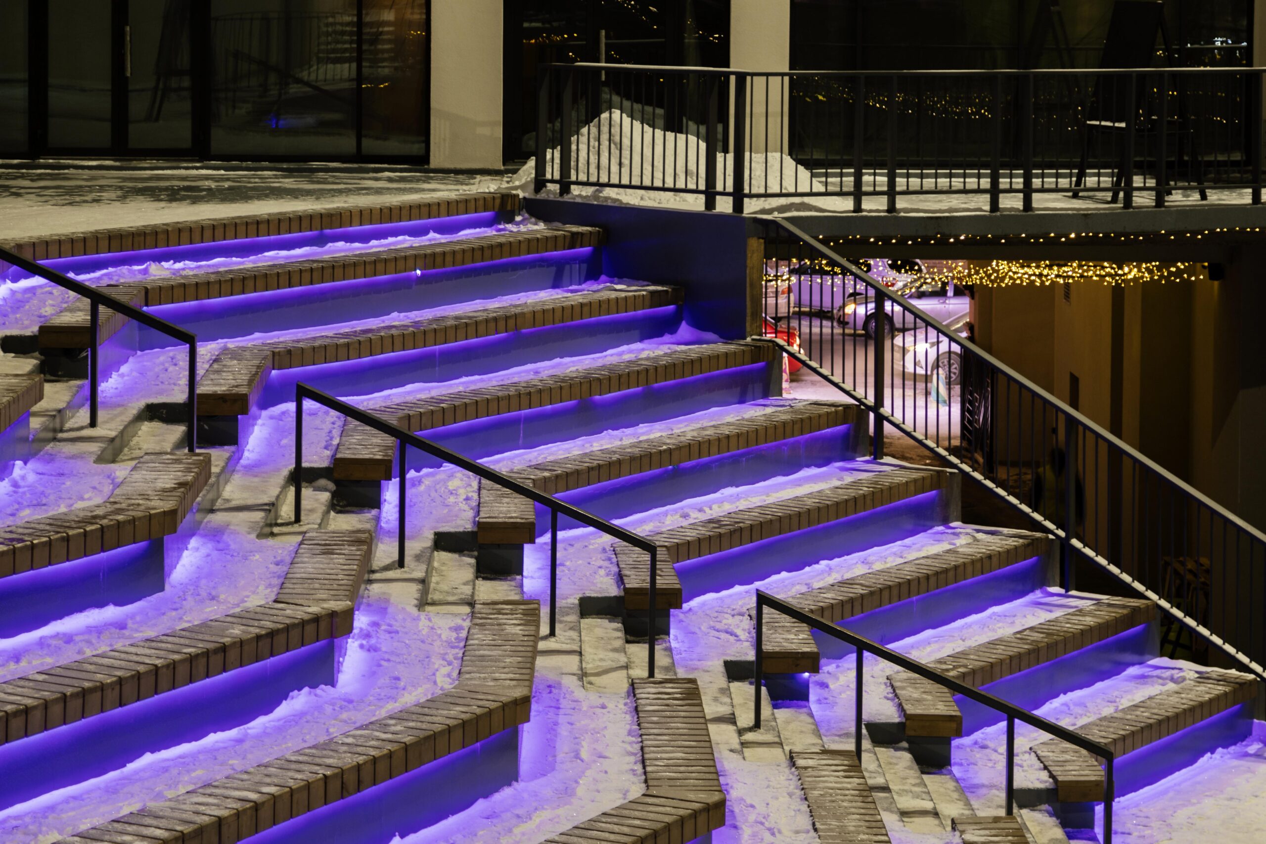 Illuminated outdoor stairs with purple ambient lighting, showcasing stylish design elements suitable for enhancing porch aesthetics and outdoor entertainment.