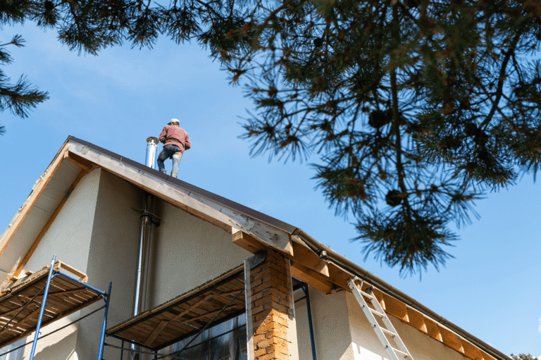 Worker on rooftop performing maintenance, showcasing exterior home services relevant to Tekton Exteriors in Raymond, MS.