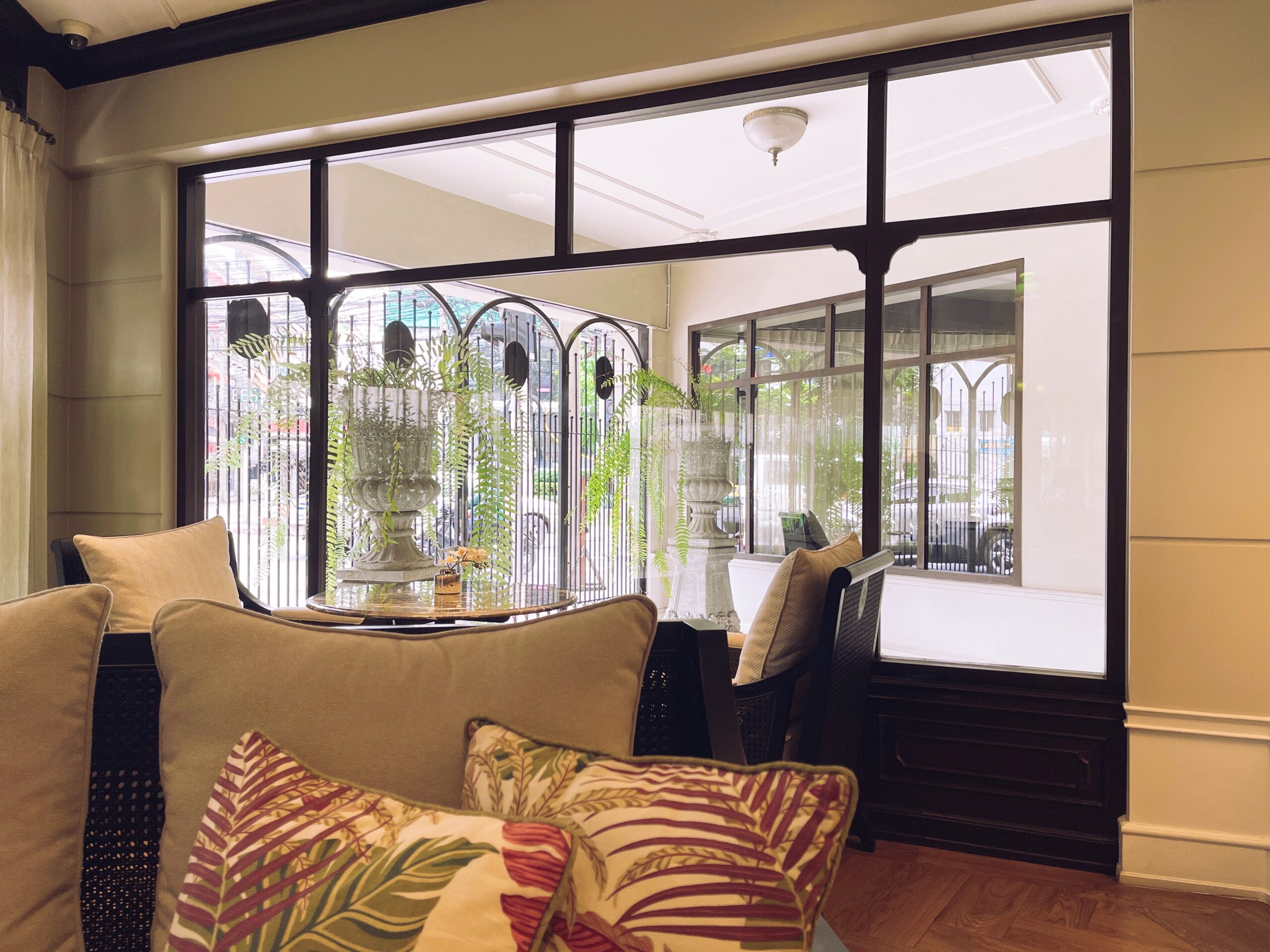 Interior view featuring Pella Sliding Windows with a modern design, showcasing a smooth glide mechanism, surrounded by decorative plants and comfortable seating, emphasizing energy efficiency and aesthetic appeal in a home setting.