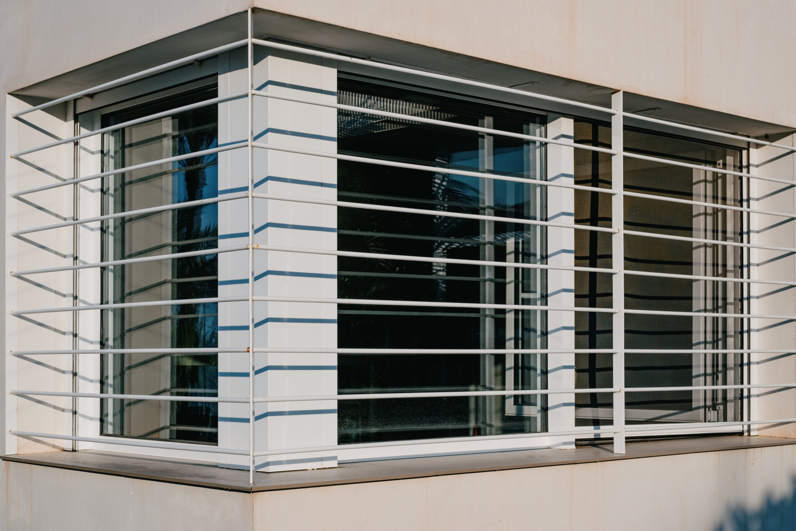 Modern Pella Awning Window with sleek white frame and horizontal metal bars, showcasing contemporary design and ventilation features for homes in Oxford, MS.